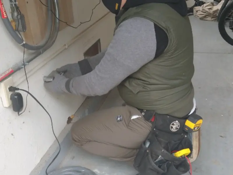 Electrician performing outlet wiring in a Saddle Brook garage